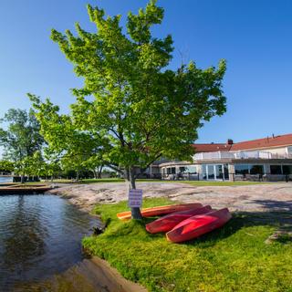 Christie's Mill Inn and Spa | Port Severn, Ontario | Exterior of Christie's Mill with lake and kayaks