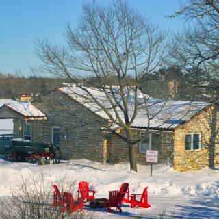 Christie's Mill Inn and Spa | Port Severn, Ontario | Outdoor brick building with Muskoka chairs during Winter