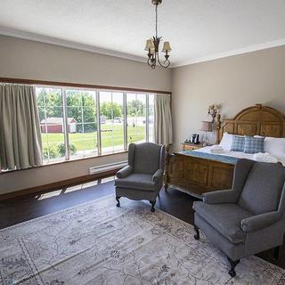 Christie's Mill Inn and Spa | Port Severn, Ontario | King bedroom with two gray chairs