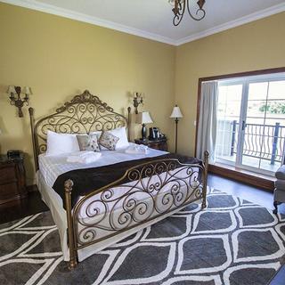 Christie's Mill Inn and Spa | Port Severn, Ontario | King bed with balcony and gray chair